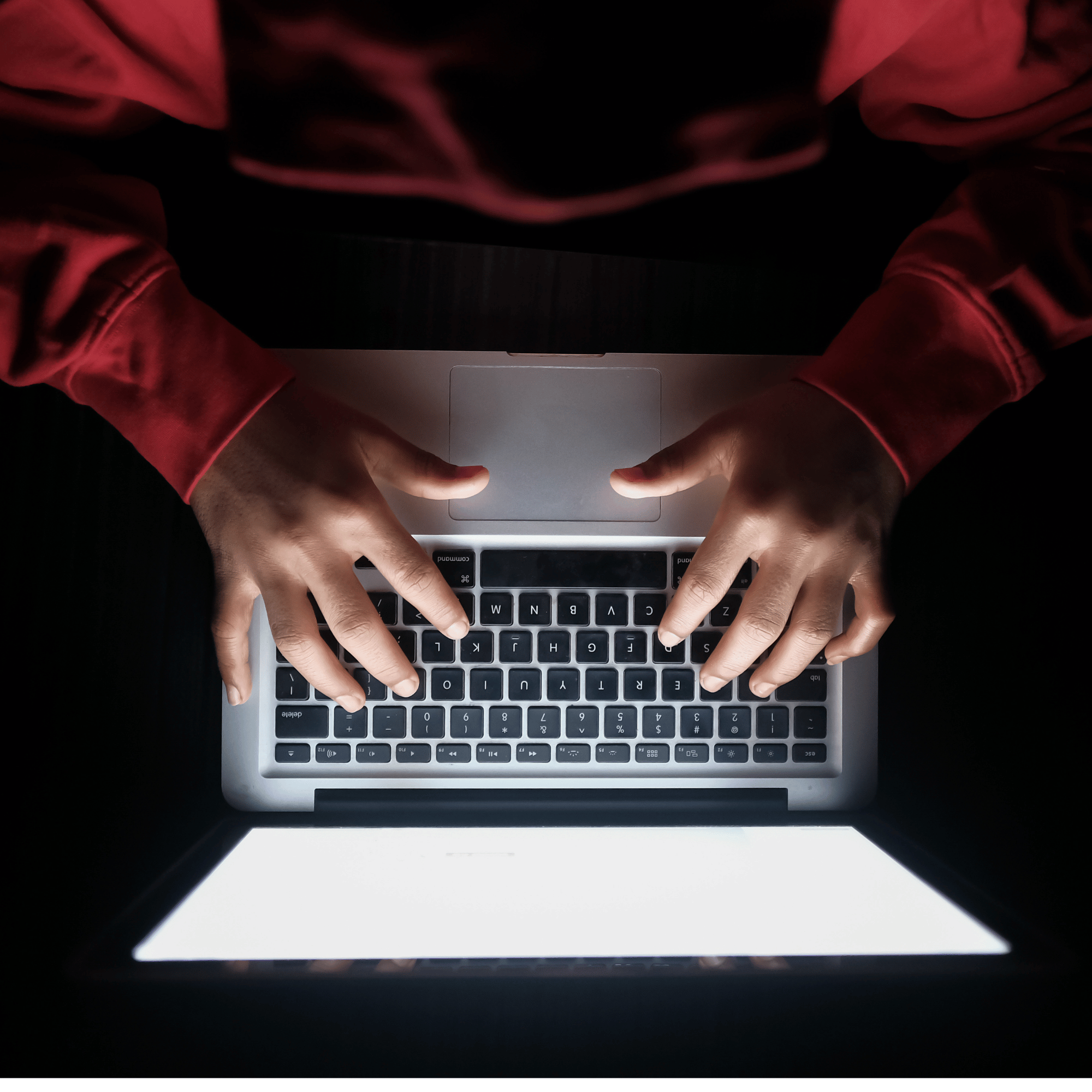 Privacy Policy image, a man on a laptop in a red hoodie typing. We are a cookieless site. Please read our policy. policy